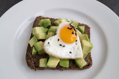 Sevgililer Günü'nde kahvaltı. yumurta ve avokado sandviç.