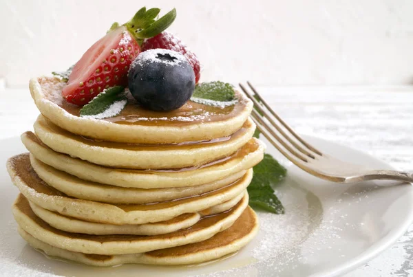 Panqueques americanos con bayas sobre un fondo claro . — Foto de Stock