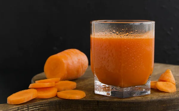 Freshly squeezed juice of carrots on black background