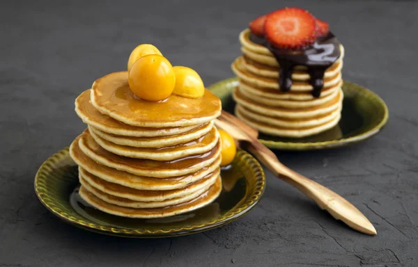 Блинчики с медом, шоколадом и ягодами на сером фоне . — стоковое фото