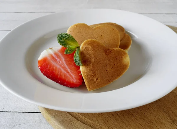 Pancakes in the shape of a heart with strawberries. — Stock Photo, Image