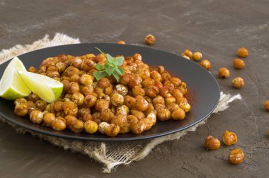 Rustik bir arka plan üzerine kavrulmuş baharatlı nohut.