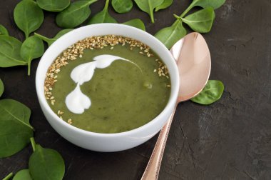 Beyaz bir tabak içinde vejetaryen ıspanak çorbası.