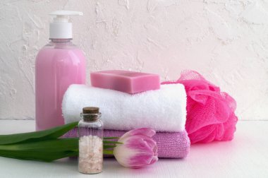 Sıvı sabun ve beyaz zemin üzerine iki havlu.