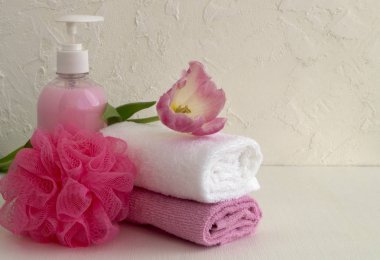 Sıvı sabun ve beyaz zemin üzerine iki havlu.