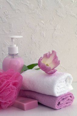 Sıvı sabun ve beyaz zemin üzerine iki havlu.