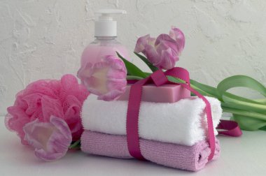 Sıvı sabun ve beyaz zemin üzerine iki havlu.