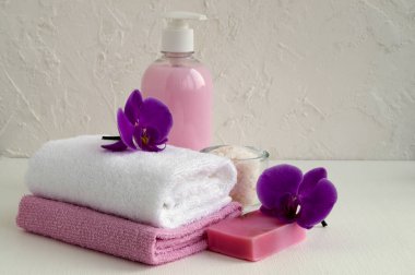 Sıvı sabun ve beyaz zemin üzerine iki havlu.