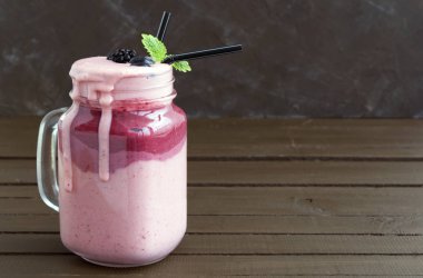 Ahşap arka plan üzerinde bir kavanoza muzlu süt.