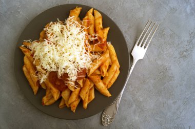 Gri arka plan üzerinde domates soslu Penne makarna.