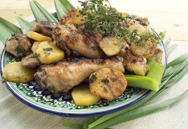 Kızarmış tavuk drumsticks patates, biberiye ve otlar ile