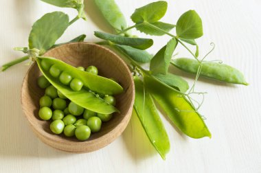 Beyaz ahşap arka plan üzerinde genç yeşil bezelye.