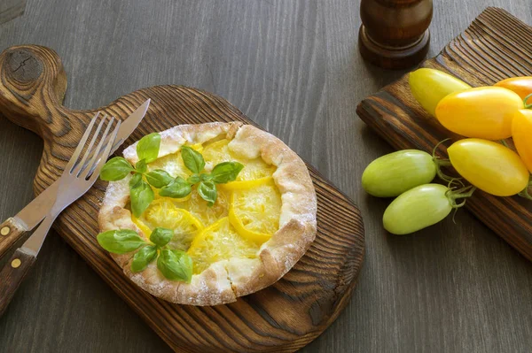 yellow tomato pie on a wooden Board.