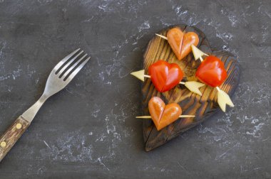 Sevgililer günü için kalp şeklinde sosis ve domatesler.