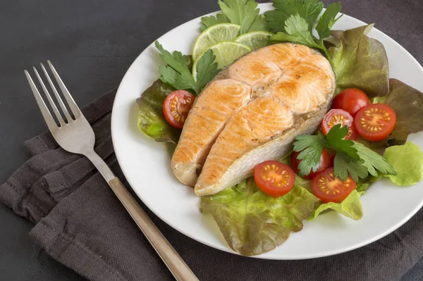 Lachssteak vom Grill mit Gemüse. auf einem dunklen Tisch. — Stockfoto