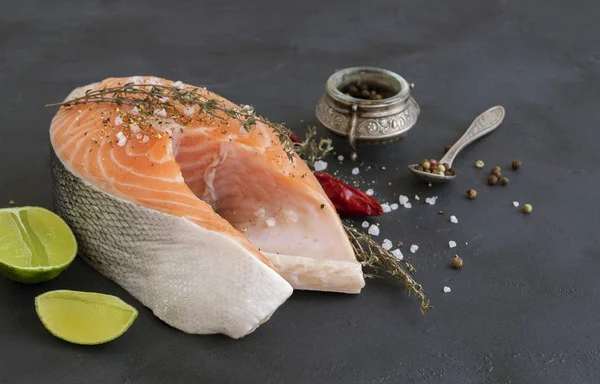 Salmon steak raw fish prepared for cooking. Top view on black ta — Stock Photo, Image