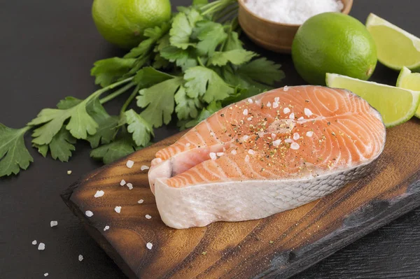 Salmon steak raw fish prepared for cooking. Top view on black ta — Stock Photo, Image