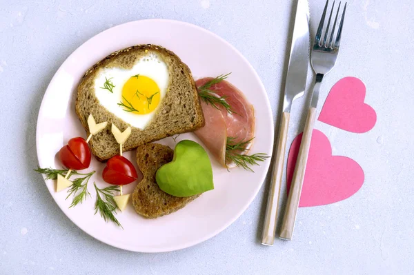 Breakfast for Valentine's day. egg and toast in the shape of a h — Stock Photo, Image