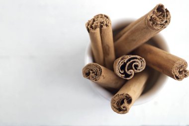 Beyaz arka planda Seylan tarçın kokulu çubukları.