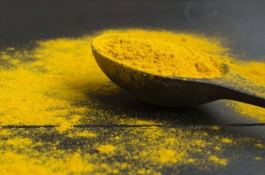 Siyah arka planda zerdeçal tozu. Doğu baharatı