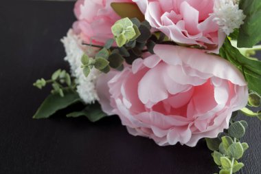 Siyah bir zemin üzerine pembe yapay peonies