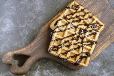 Tahta üzerinde çikolata şurubu olan Belçika çikolatalı waffle 'ları..