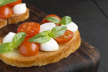 Olgun domatesli Caprese salatası ve taze fesleğen yapraklı mozzarella. İtalyan yemeği..