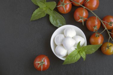 Olgun domatesli Caprese salatası ve taze fesleğen yapraklı mozzarella. İtalyan yemeği..