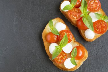 Olgun domatesli Caprese salatası ve taze fesleğen yapraklı mozzarella. İtalyan yemeği..