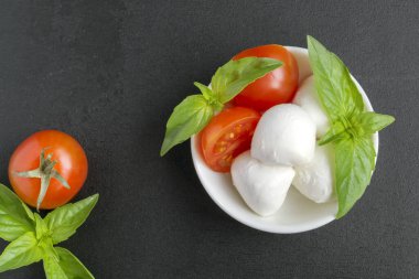 Olgun domatesli Caprese salatası ve taze fesleğen yapraklı mozzarella. İtalyan yemeği..