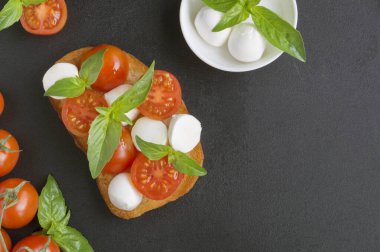 Olgun domatesli Caprese salatası ve taze fesleğen yapraklı mozzarella. İtalyan yemeği..
