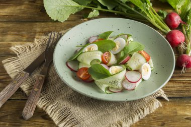 Tahta bir masada taze sebzeli bahar vitamin salatası..