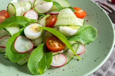 Tahta bir masada taze sebzeli bahar vitamin salatası..