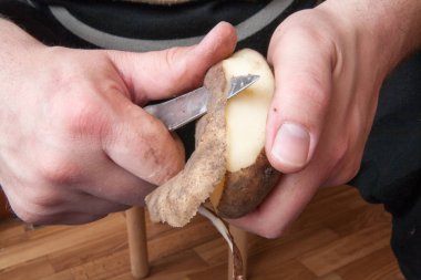 Bir patates mutfak bıçağıyla soyuluyor.