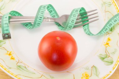 Ölçüm bandı ve bir çatal ile domates izole 