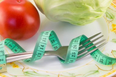 Ölçüm bandı ve bir çatal ile domates izole 