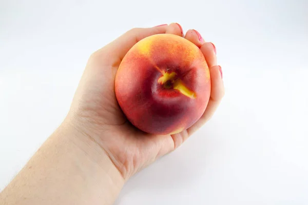 Käsi tuoreen mehukas persikka jakaa kahtia eristetty — kuvapankkivalokuva