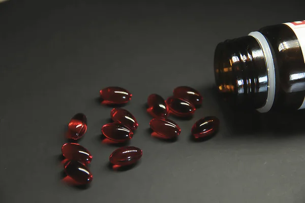 Vaccine, red capsules on a black background