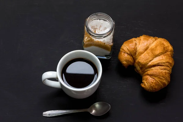 Färsk croissant och svart kaffe till frukost — Stockfoto