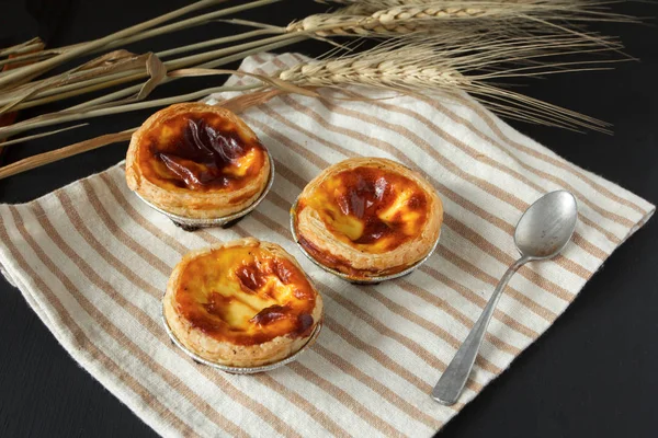 Egg tart sweet custard pie in foil cup on black background — Stock Photo, Image