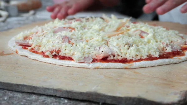 Cook making delicious pizza at the restaurant, close-up — Stock Photo, Image