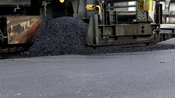 Ascheplatten-Pflastermaschine bei Straßenerneuerungsarbeiten. lizenzfreie Stockbilder