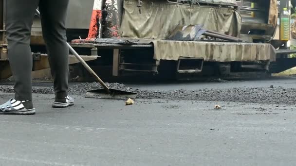 Een weg bemanning reparaties de straat van de stad — Stockvideo