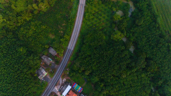 Vista aérea sobre estrada de montanha passando pela paisagem florestal em — Fotografia de Stock