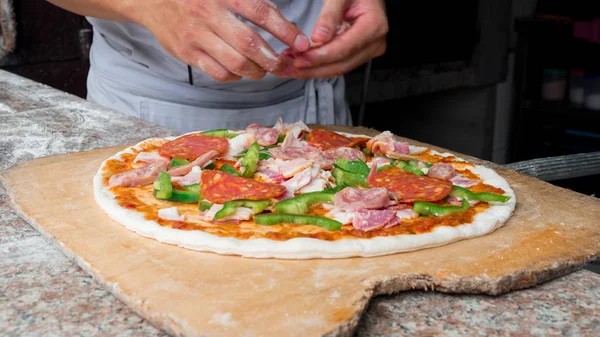 Cook making delicious pizza at the restaurant, close-up — Stock Photo, Image