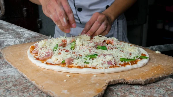 Cheese being spread on tomato sauce on pizza base. Selective foc — Stock Photo, Image