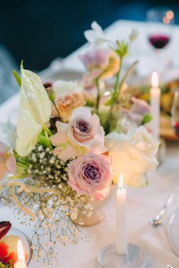 Çiçek buketli, mumlu bir festival masası.