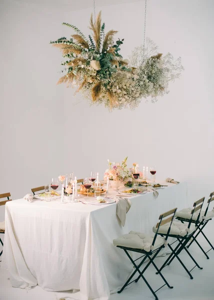 Mesa Festiva Com Buquê Floral Velas Vinhos Alimentos Cadeiras Guirlanda — Fotografia de Stock