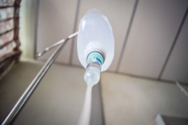 Solución salina IV de sujeción manual para el paciente en la habitación del hospital — Foto de Stock
