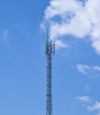 Mikrodalga bağlantı antenler üzerinde mavi bir gökyüzü ile telekomünikasyon mast.